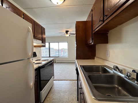 an empty kitchen with a sink and a refrigerator