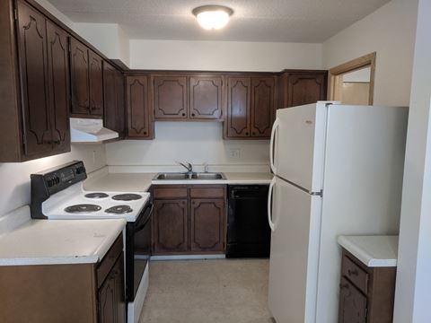 Kitchen showing stove top, oven, fridge and sink at John Snell Apartments