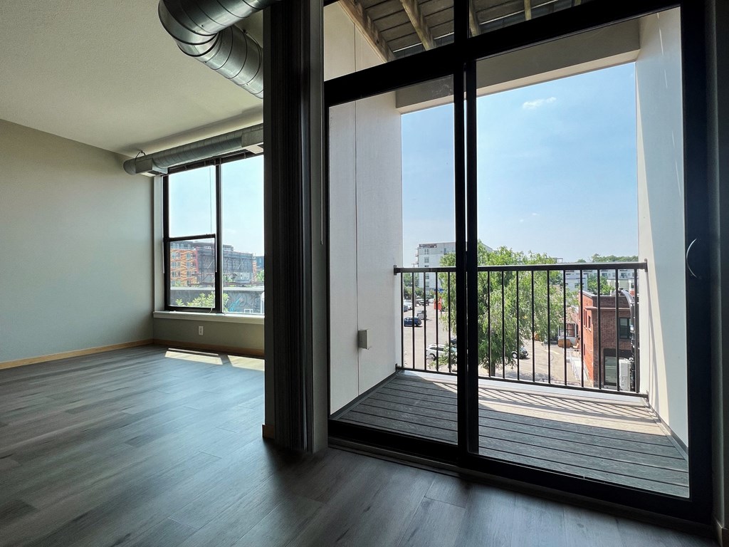 an open living room with large windows and a balcony