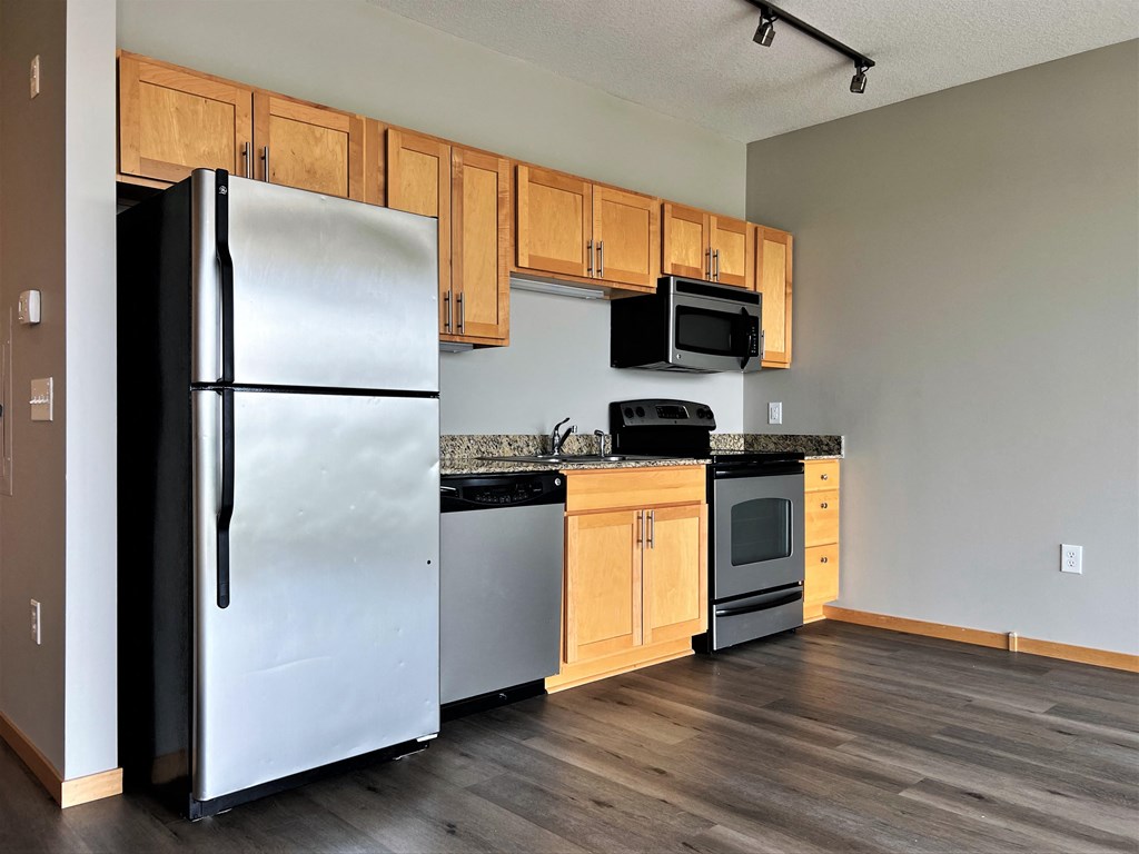 a kitchen with wooden cabinets and stainless steel appliances