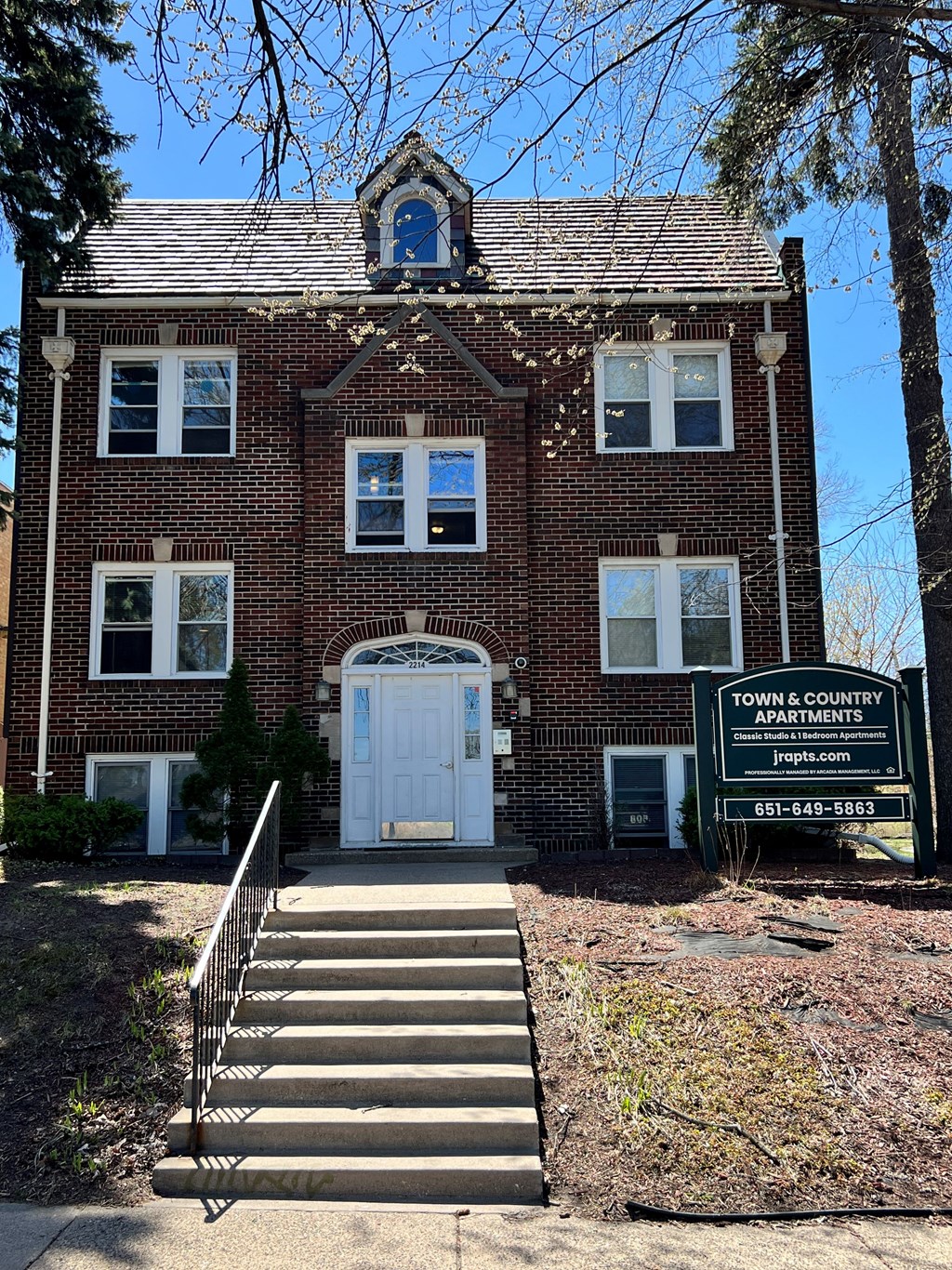 a large brick building with a white door and a sign in front of it