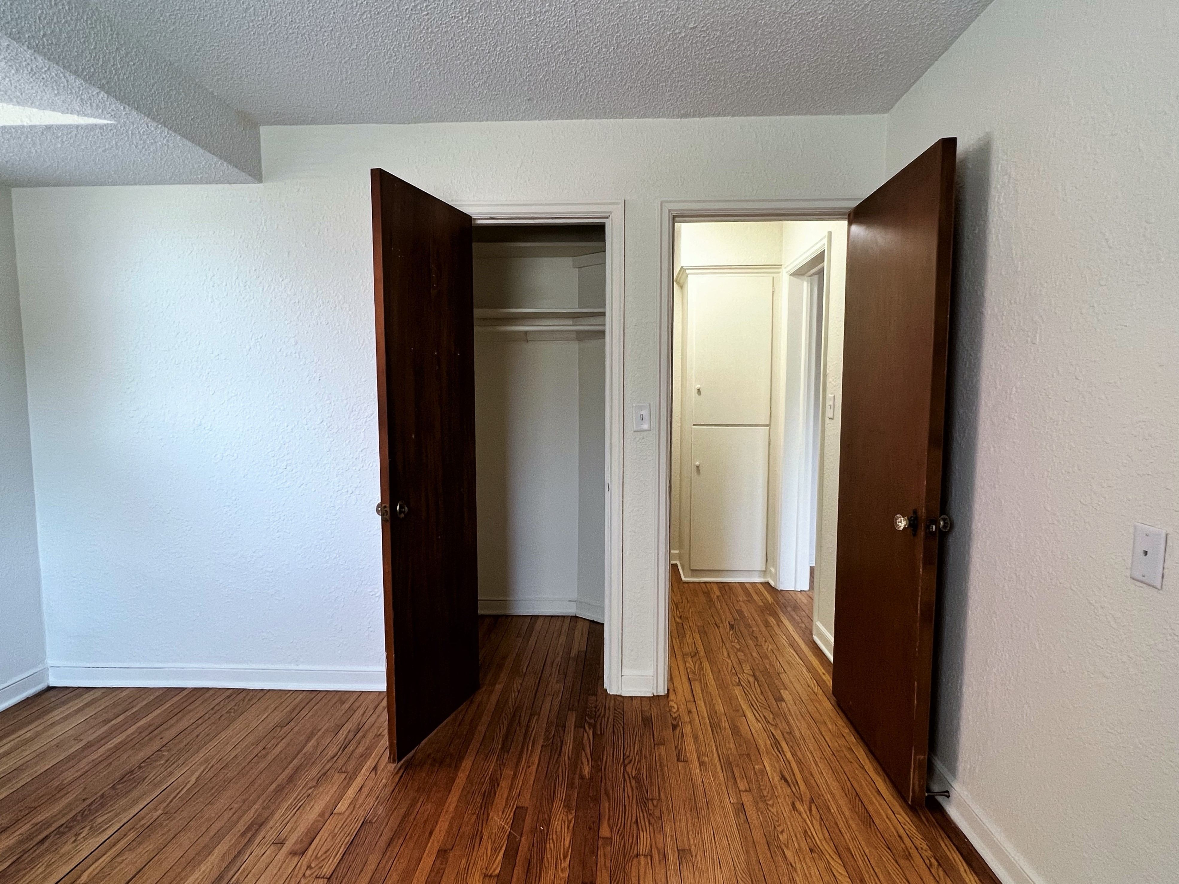 a bedroom with a door open to a hallway with a closet