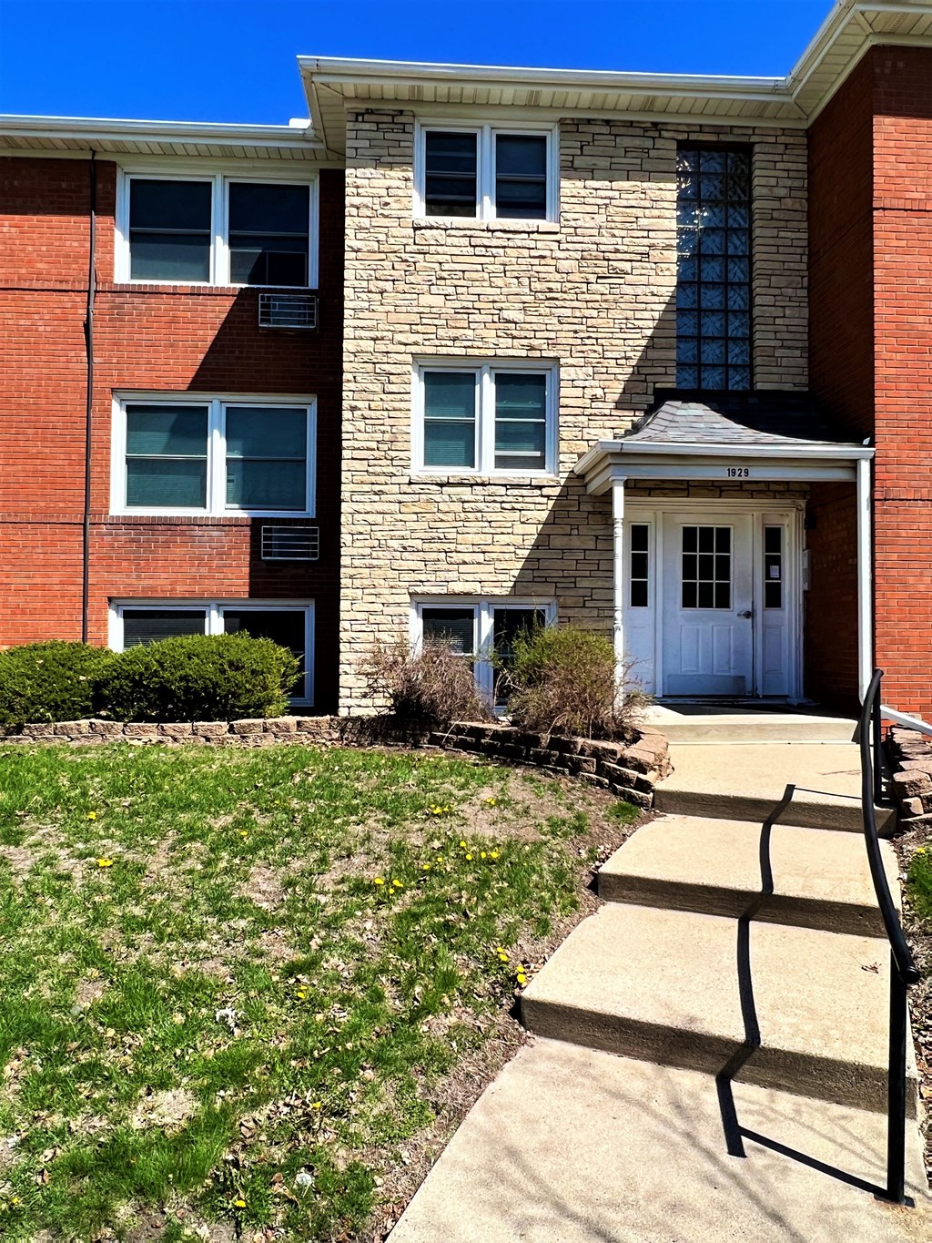 a walkway leads to the front door of an apartment building
