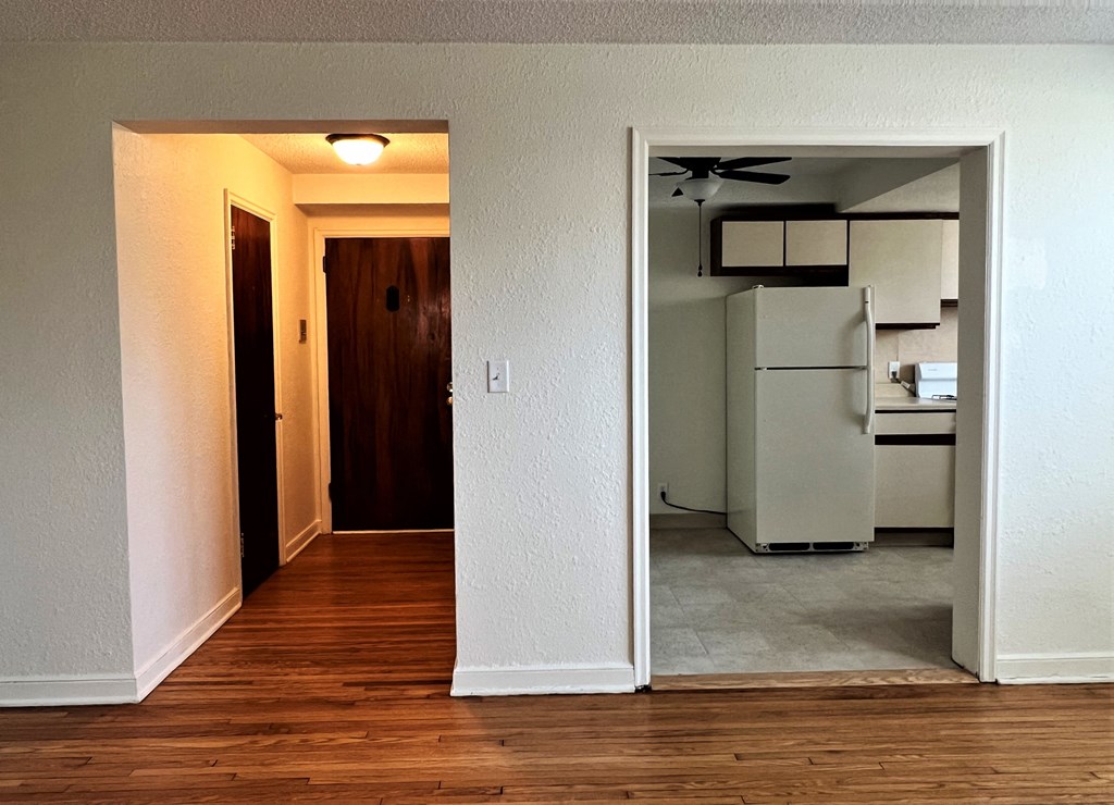 an open door leading to a kitchen and living room