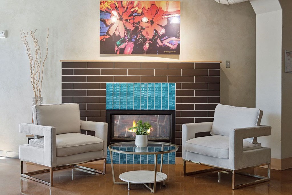 a living room with a fireplace and two chairs