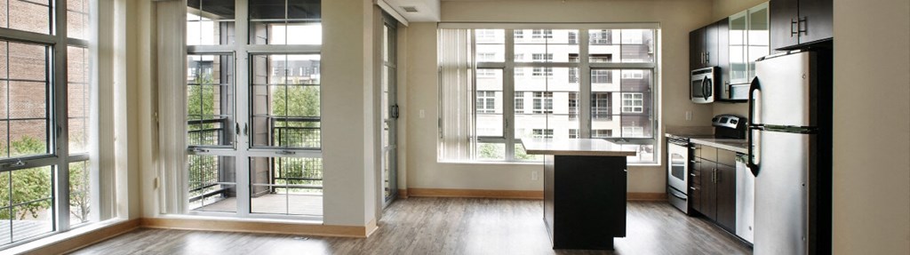 a kitchen with large windows and a wooden floor