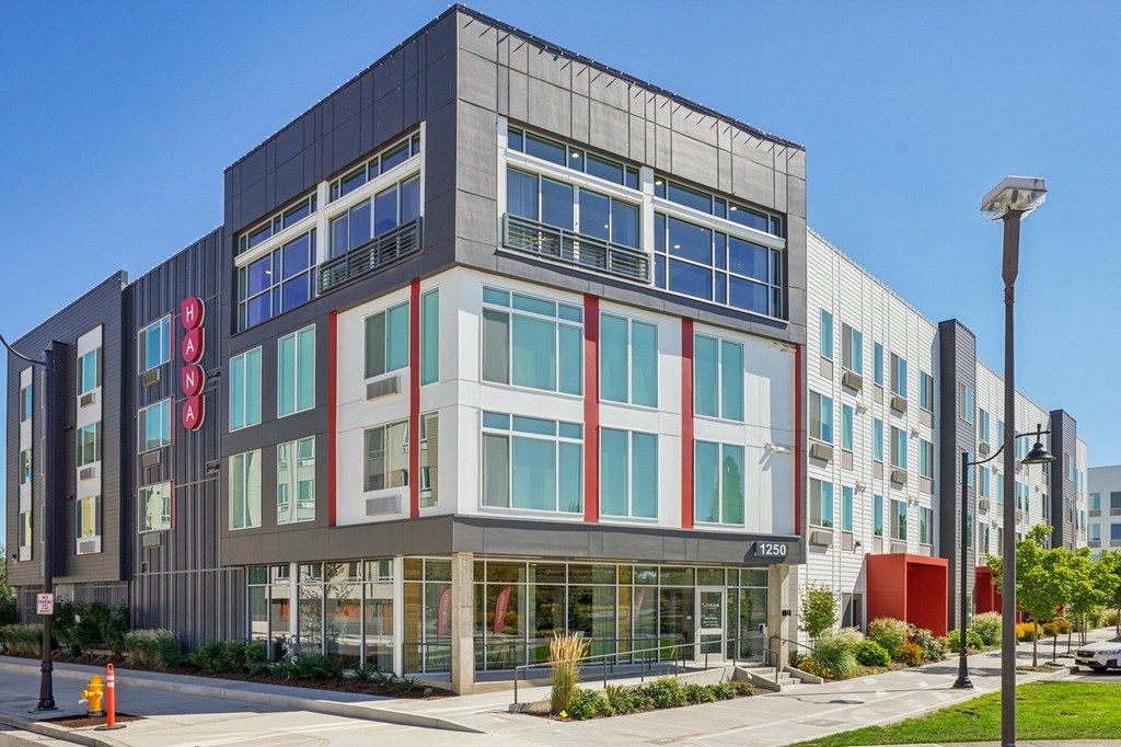 A modern building with a red sign on the left side.