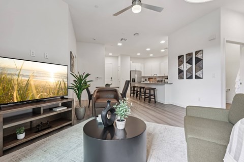 A modern living room with a flat screen TV and a bar area.