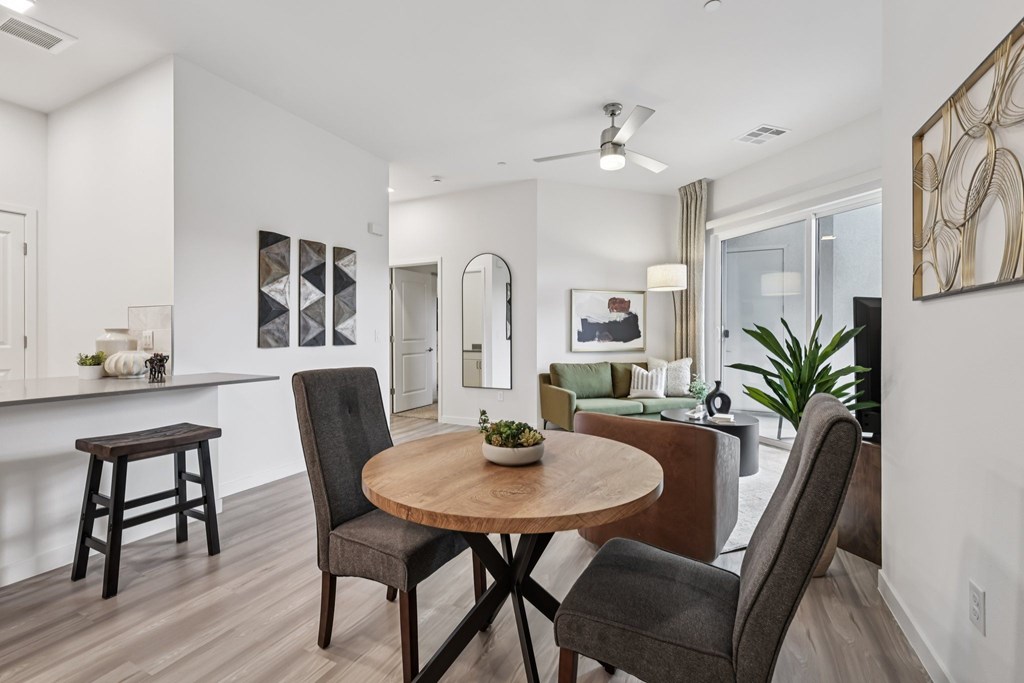 A modern dining room with a round wooden table and chairs.