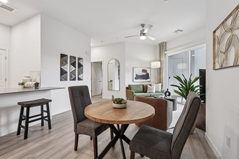 A modern dining room with a round wooden table and chairs.