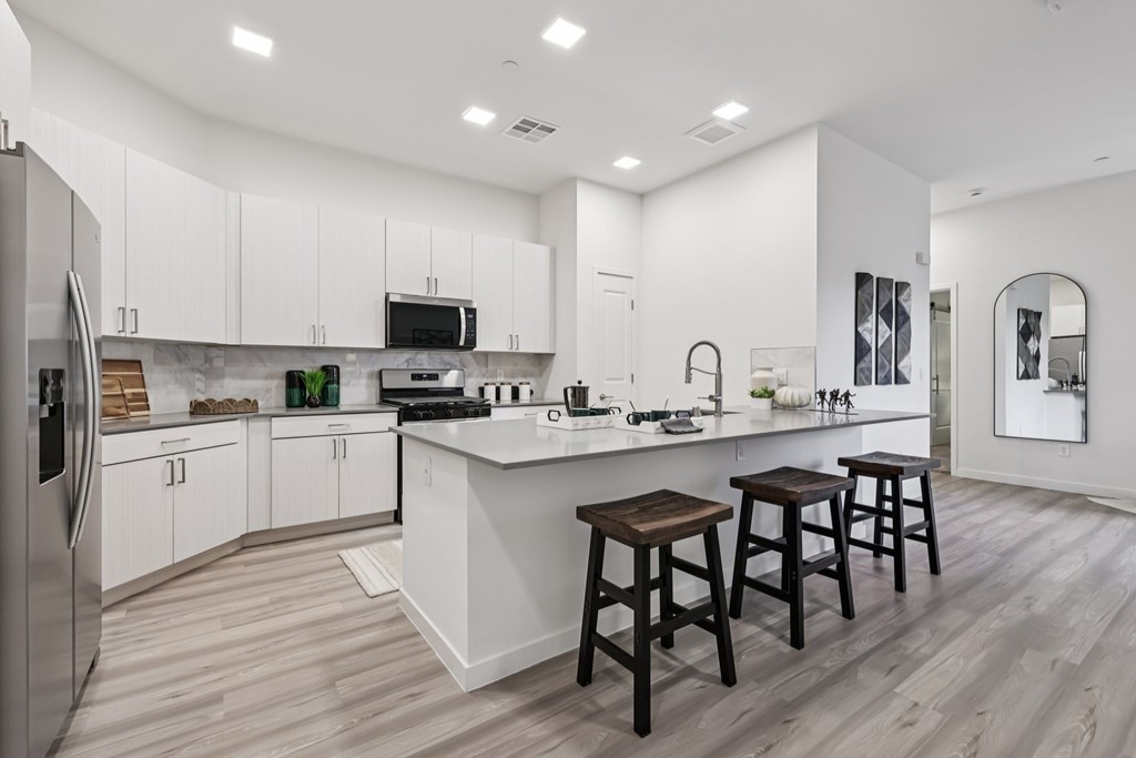 A modern kitchen with white cabinets and a central island.
