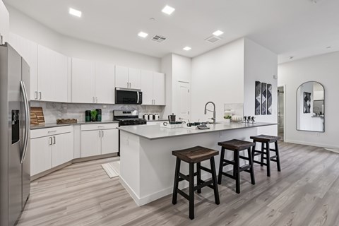 A modern kitchen with white cabinets and a central island.