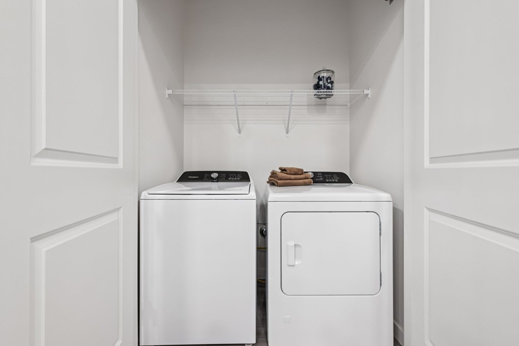 Two white washing machines in a laundry room.