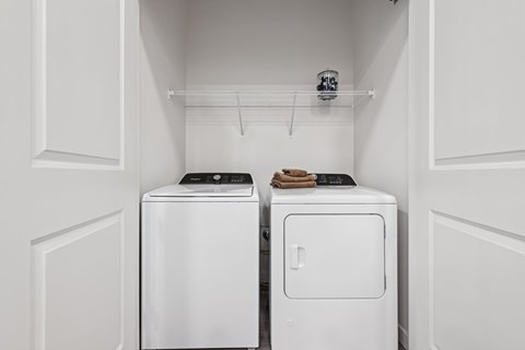 Two white washing machines in a laundry room.
