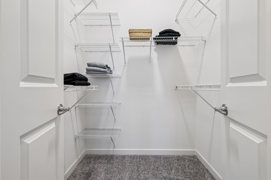 A white closet with shelves and clothes.