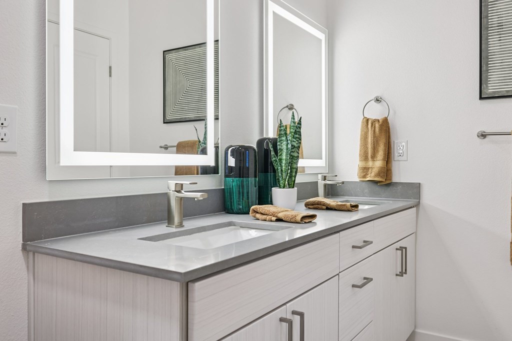 A bathroom with a white sink and a mirror above it.