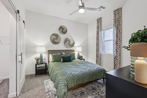 A bedroom with a bed, nightstands, and a ceiling fan.