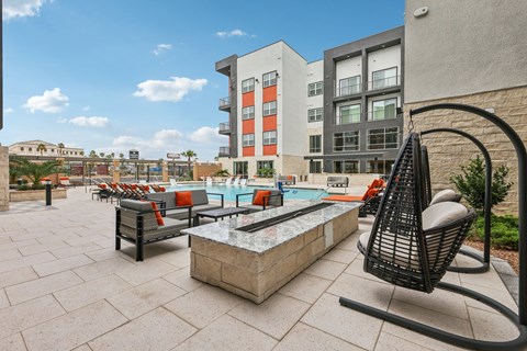 A patio with a table and chairs overlooking a pool.