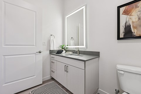 A bathroom with a white door, a sink, and a bathtub.
