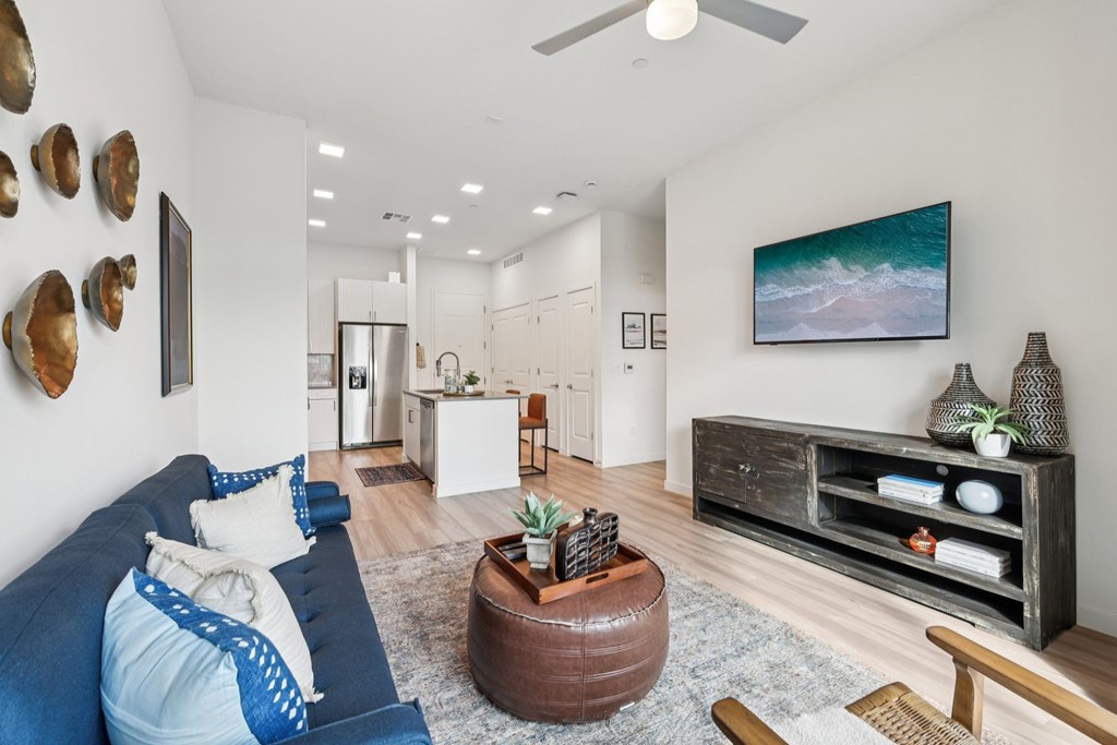 A living room with a blue couch and a brown coffee table.