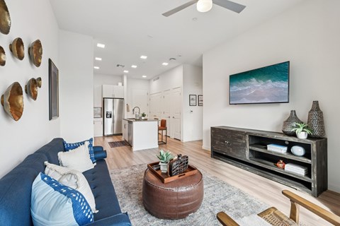 A living room with a blue couch and a brown coffee table.