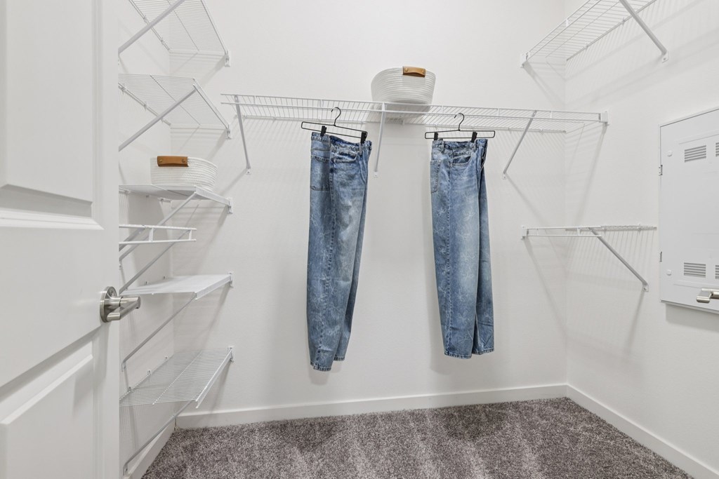 A pair of jeans hanging on a clothesline in a white room.