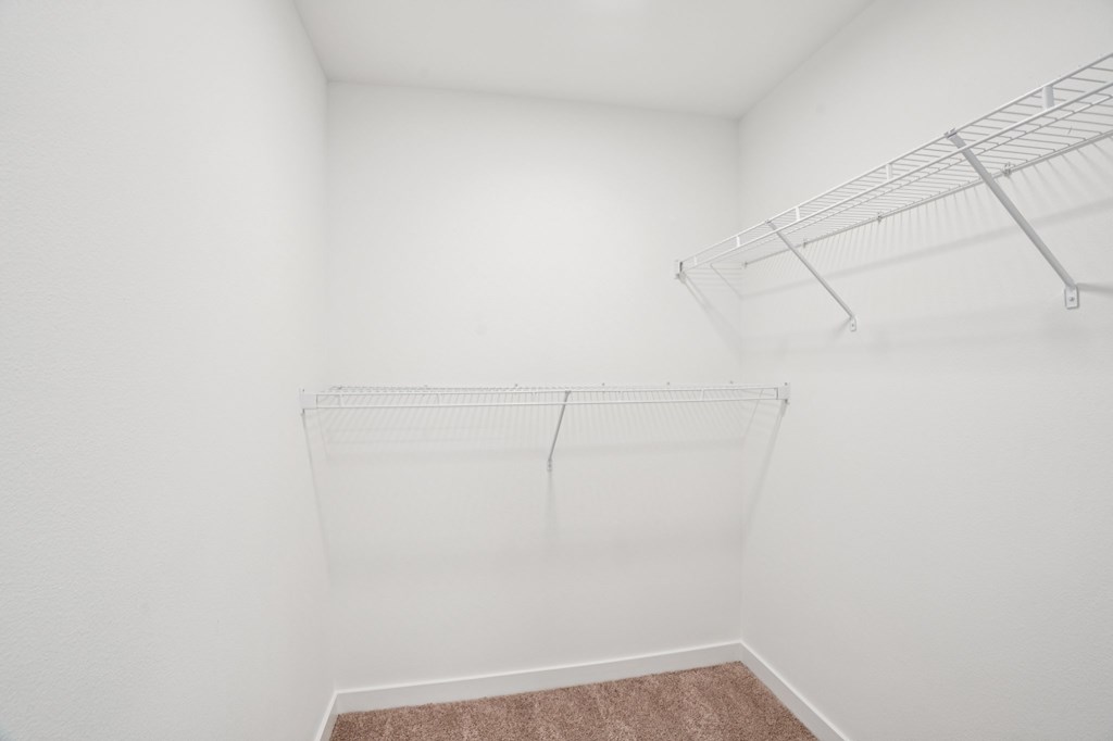 Empty room with a shelf and a carpeted floor.