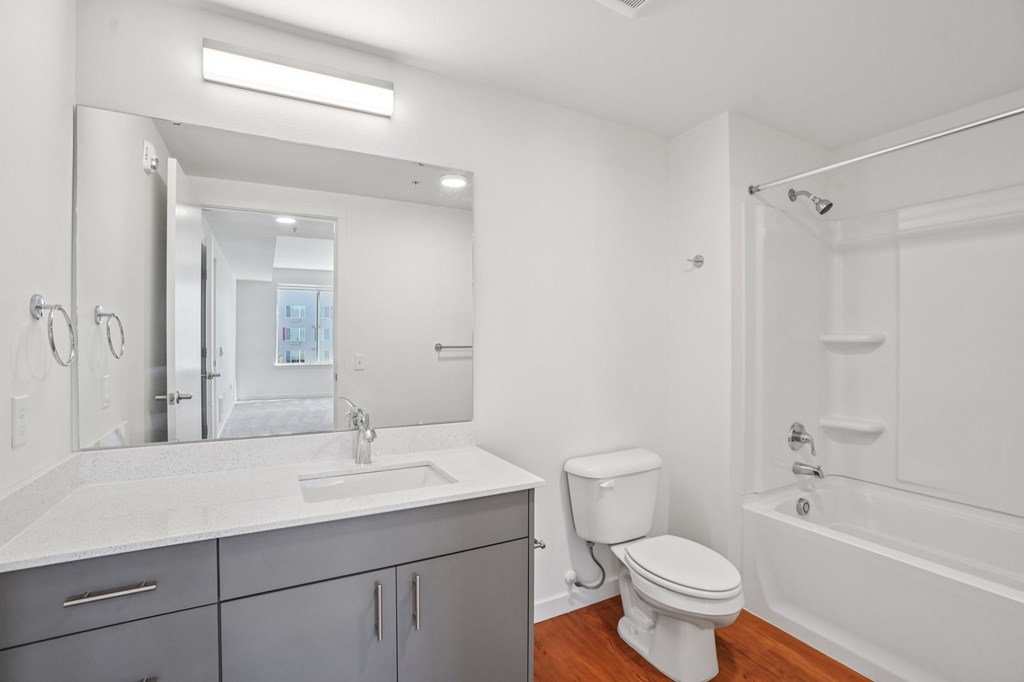 A white bathroom with a toilet, sink, and bathtub.