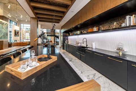 a large kitchen with black counters and a marble table