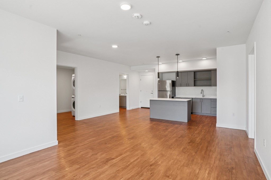 A large empty room with wooden floors and white walls.