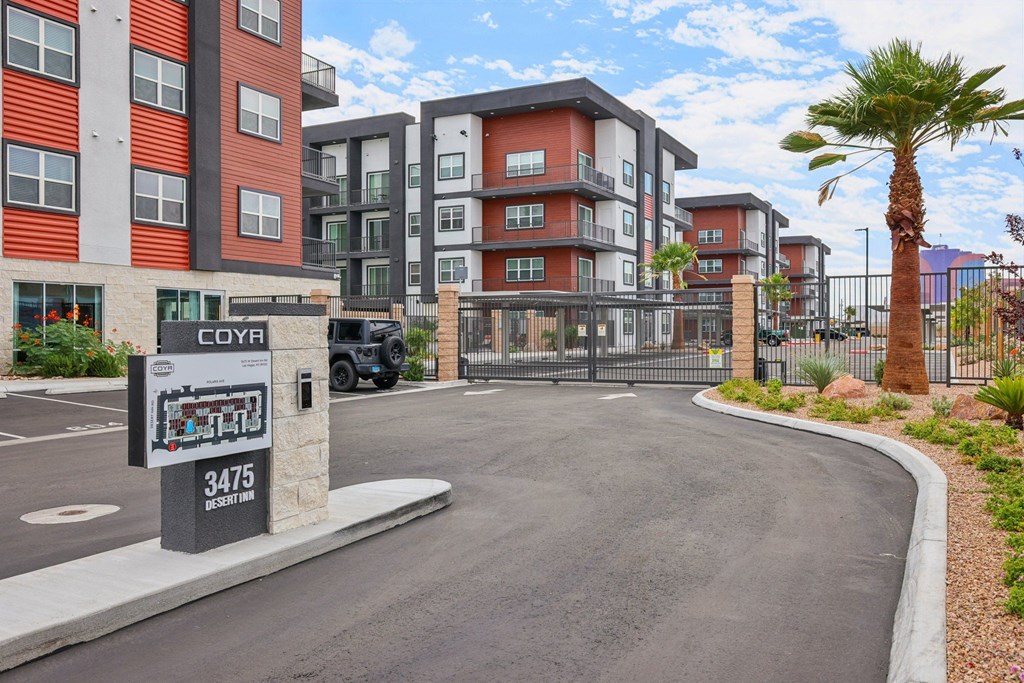 A street view of a residential area with apartment buildings and a palm tree.