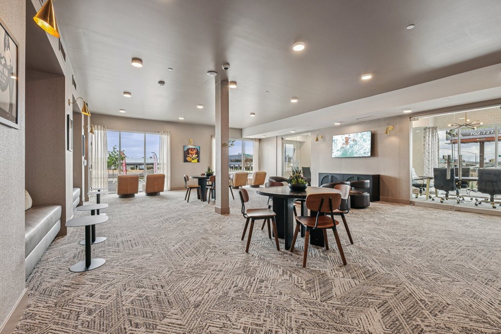 A spacious room with a carpeted floor and a long table with chairs.