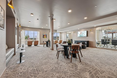 A spacious room with a carpeted floor and a long table with chairs.