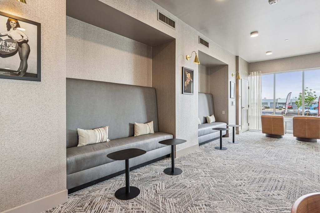 A grey couch with a black table in front of it.