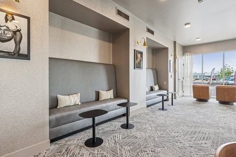 A grey couch with a black table in front of it.