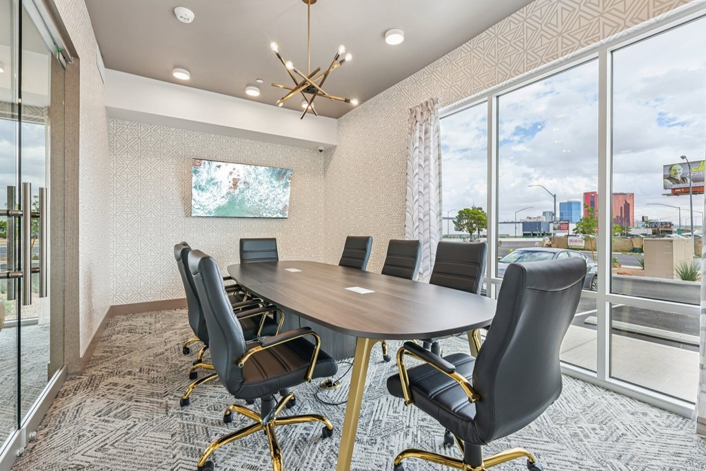 A conference room with a large table and chairs.