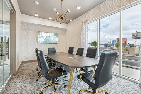 A conference room with a large table and chairs.