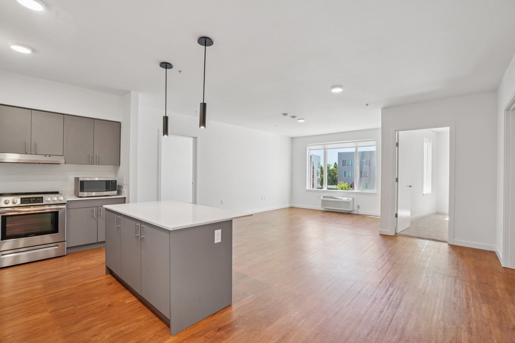 A modern kitchen with wooden floors and a large island.