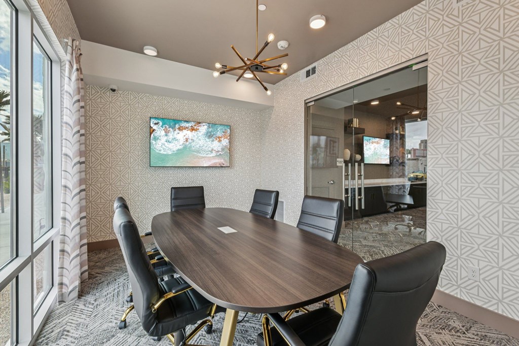 A conference room with a large table and chairs.