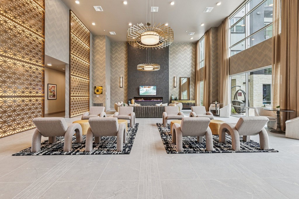 A modern waiting area with a patterned wall and grey chairs.