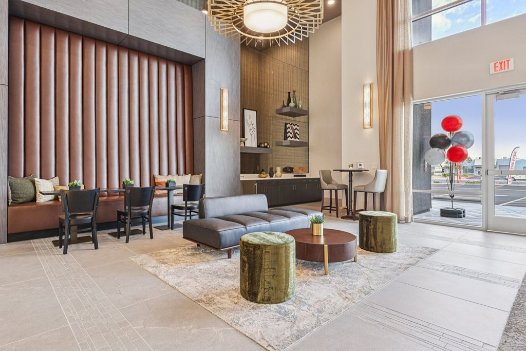 A large room with a couch, chairs, and a table with a bottle on it.