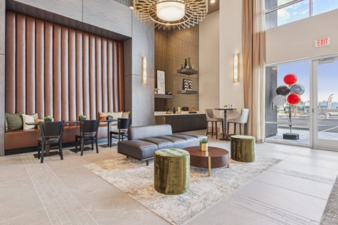 A large room with a couch, chairs, and a table with a bottle on it.