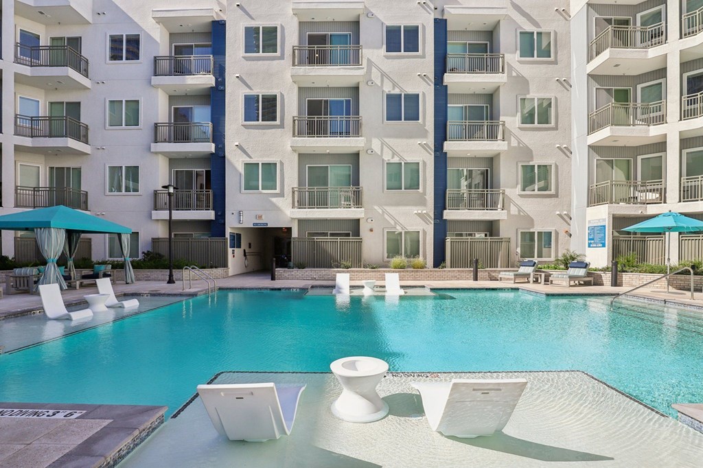 A large white building with a pool in front.