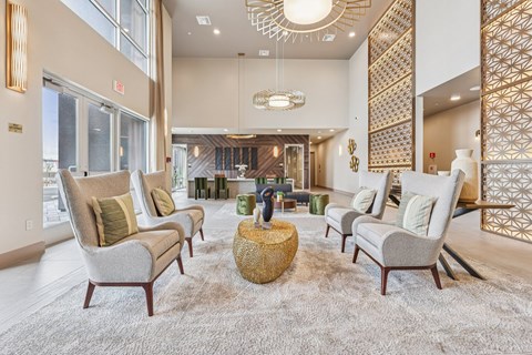 A living room with a large rug and four chairs.