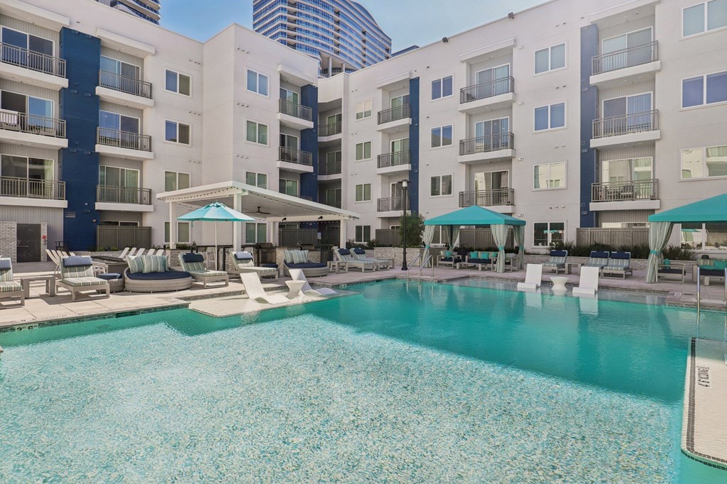 A large swimming pool in front of apartment buildings.