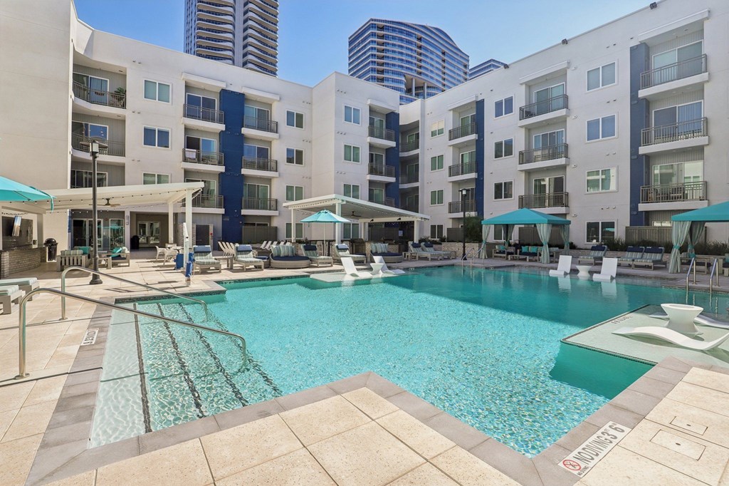 A large swimming pool surrounded by apartment buildings.