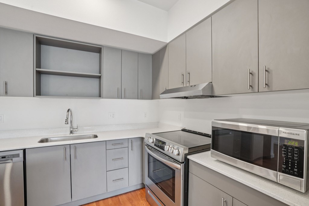 A modern kitchen with a stove, oven, and microwave.