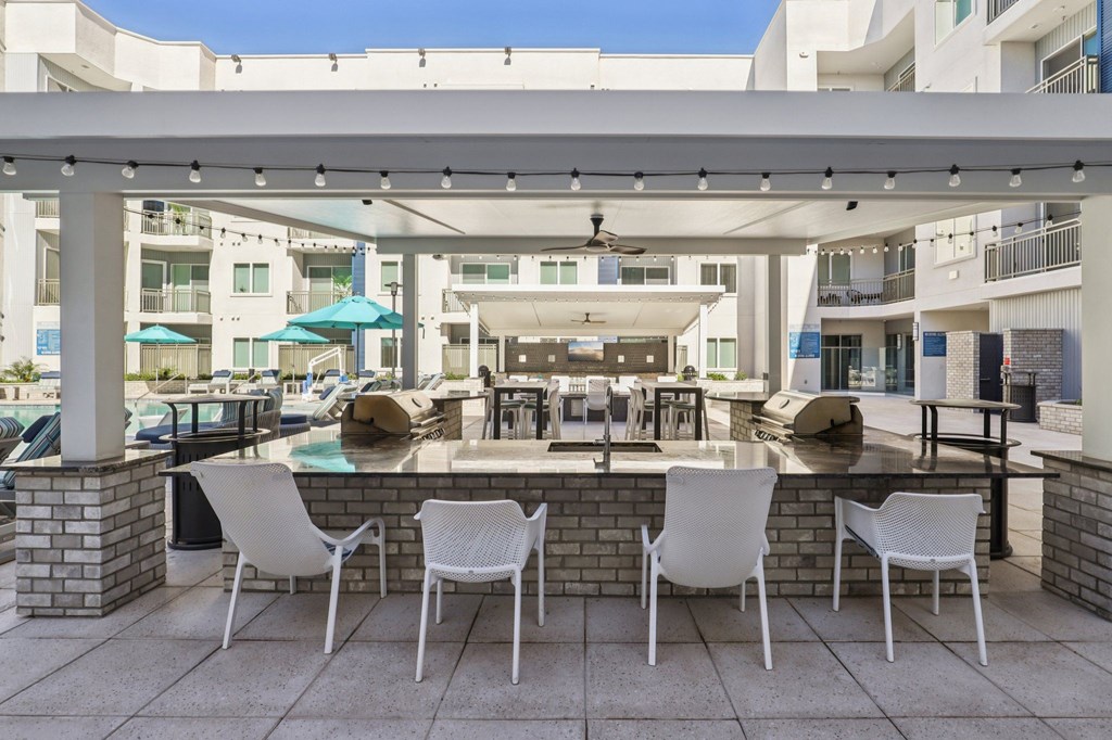 A patio with white chairs and a table is set up.