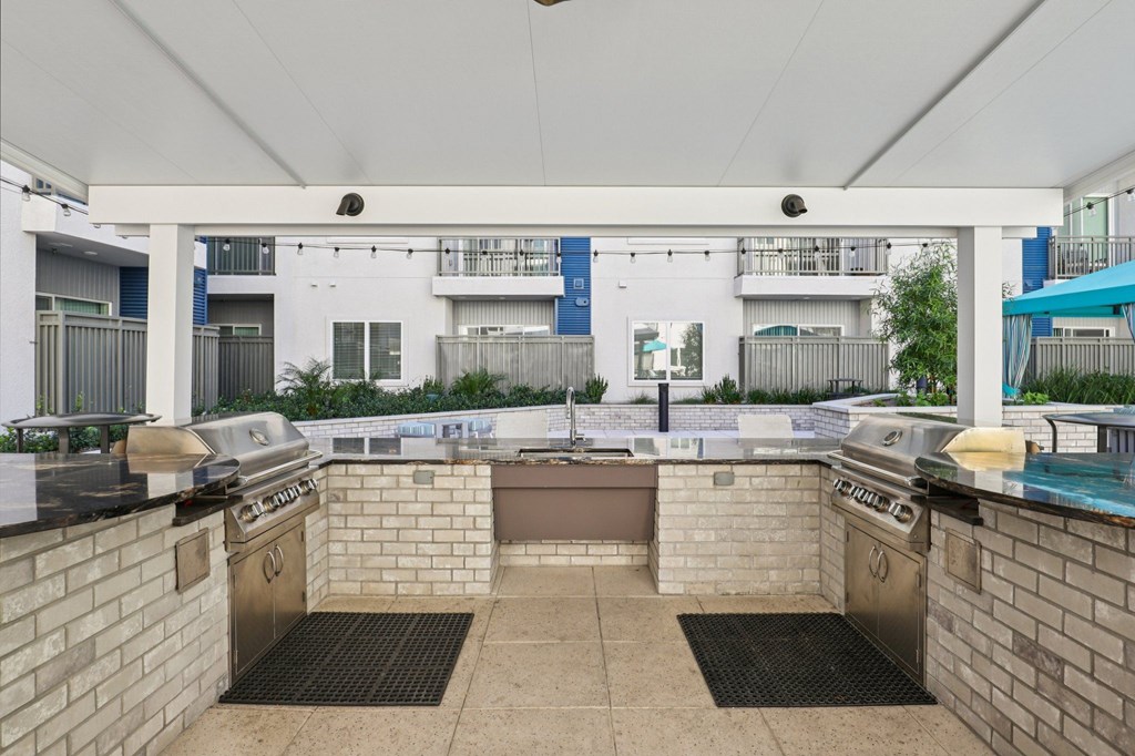 A patio with a grill and a table with a grill on it.