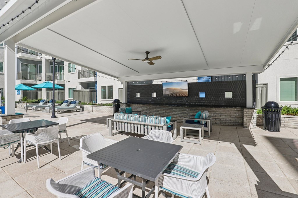 A patio with a table and chairs under a white canopy.